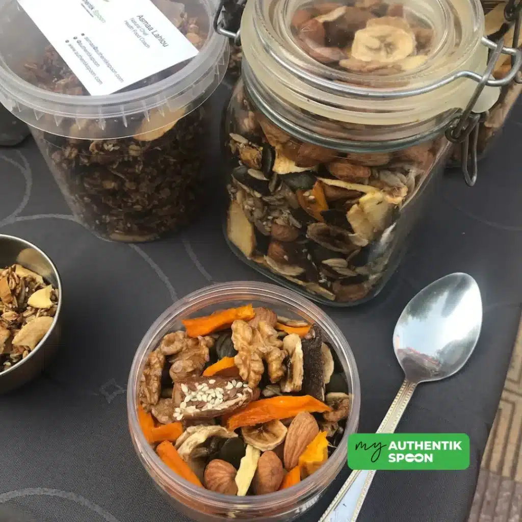 Multiple jars and bowls of homemade activated trail mix displayed on a table.
