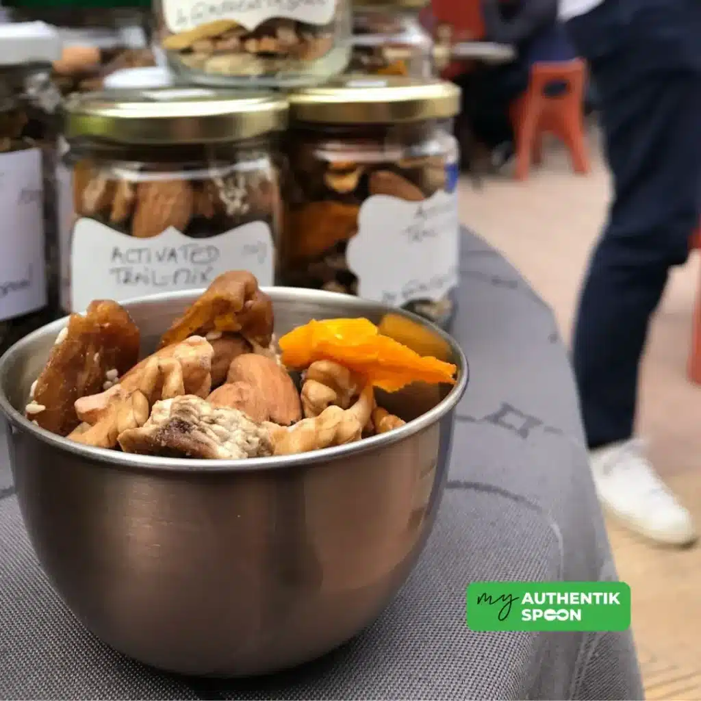 Activated trail mix recipe in a stainless steel bowl with visible walnuts, almonds, and dried mango.
