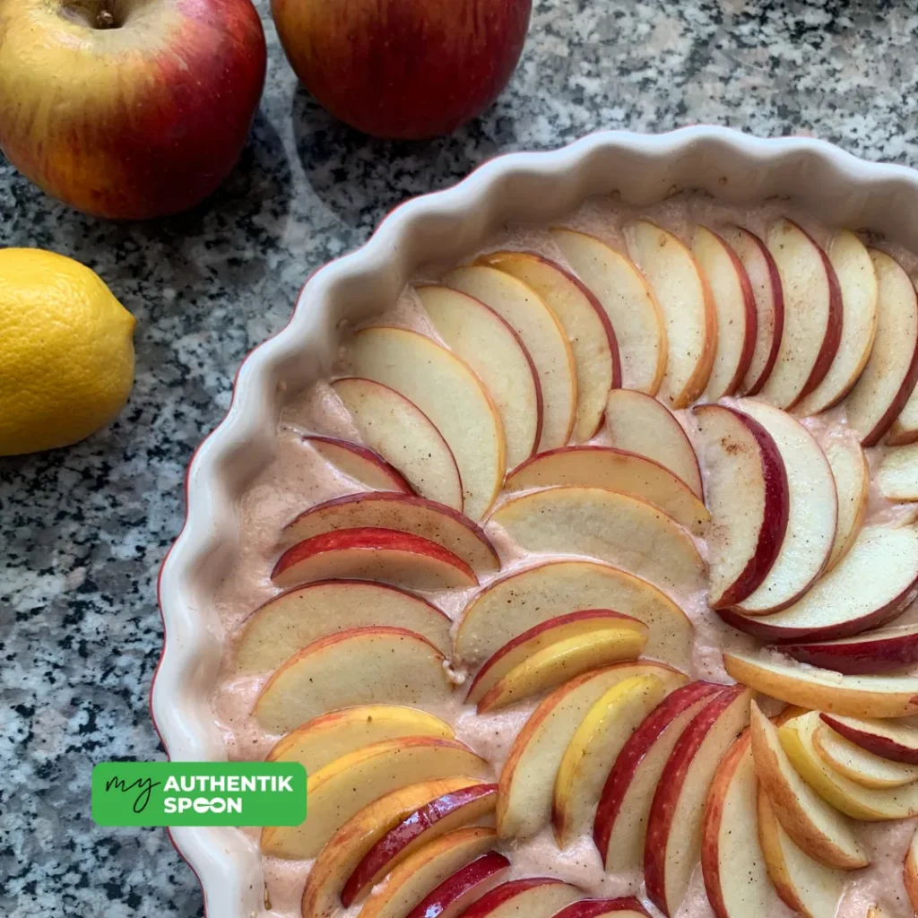 grain-free sugar-free apple clafoutis batter topped with sliced apples before baking