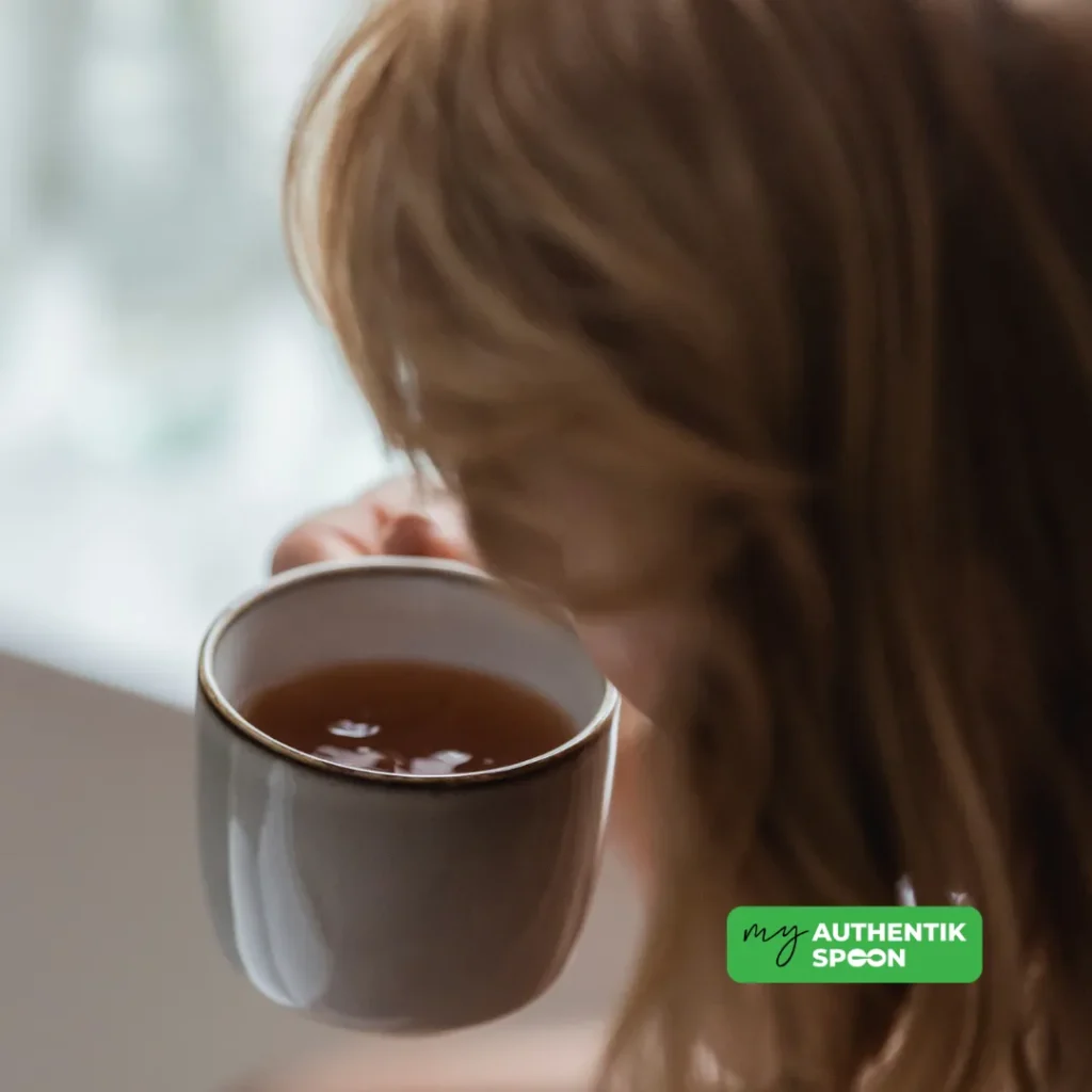 Woman enjoying a calming herbal tea ritual to support digestion after 35, reduce stress and improve gut health naturally