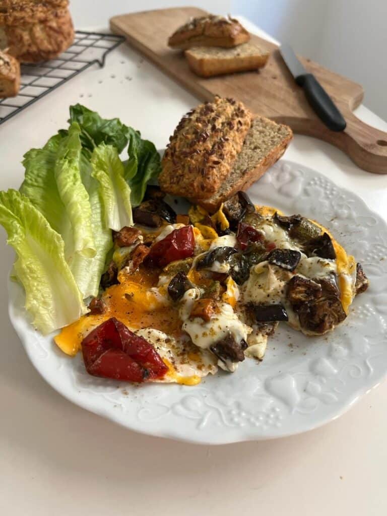 Easy Thermomix Grain-free coconut bread served with a fresh salad and roasted vegetables on a plate.
