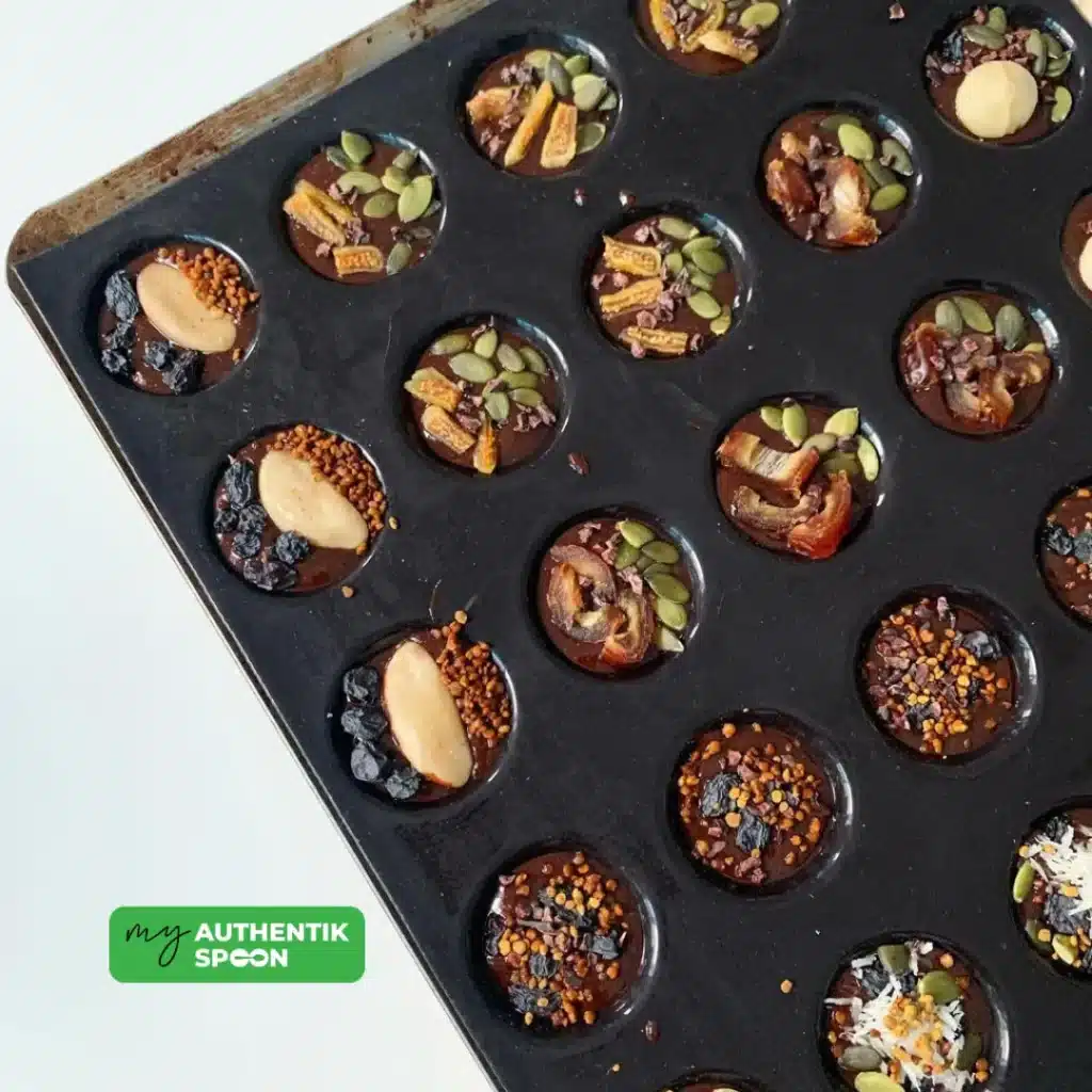 Homemade healthy chocolate bites with seeds, cacao nibs and dried fruit toppings