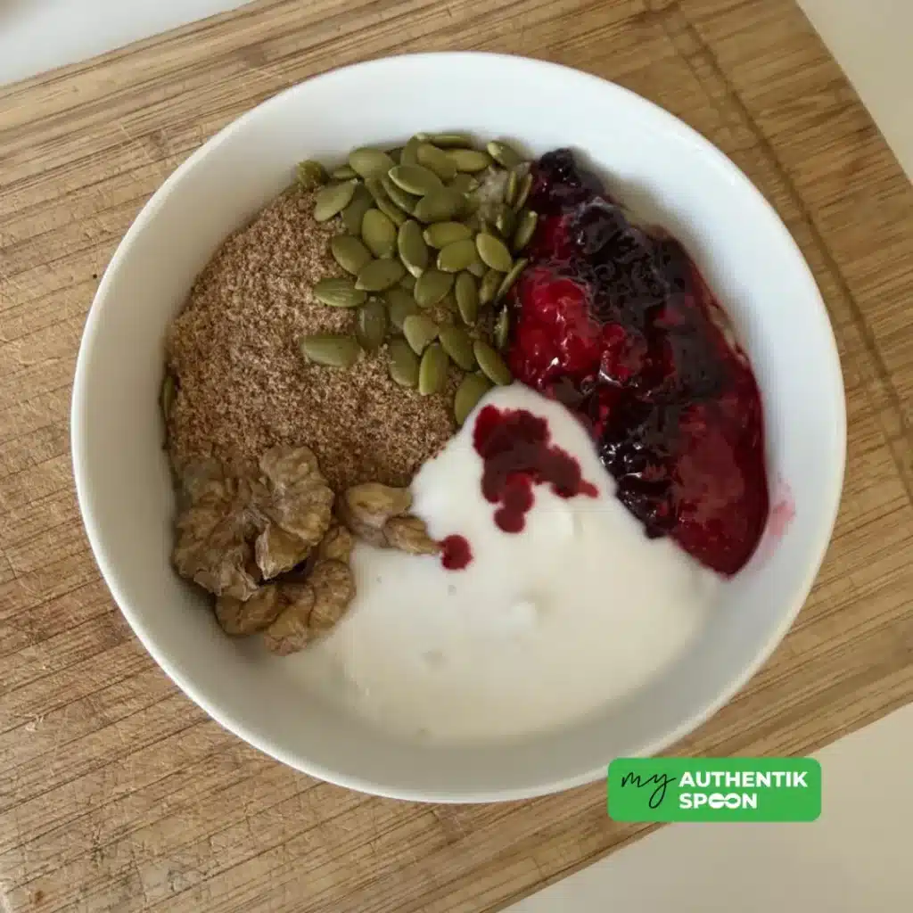 Creamy hormone balancing breakfast bowl topped with seeds, walnuts, berries and yogurt for gut health, energy and healthy weight loss.