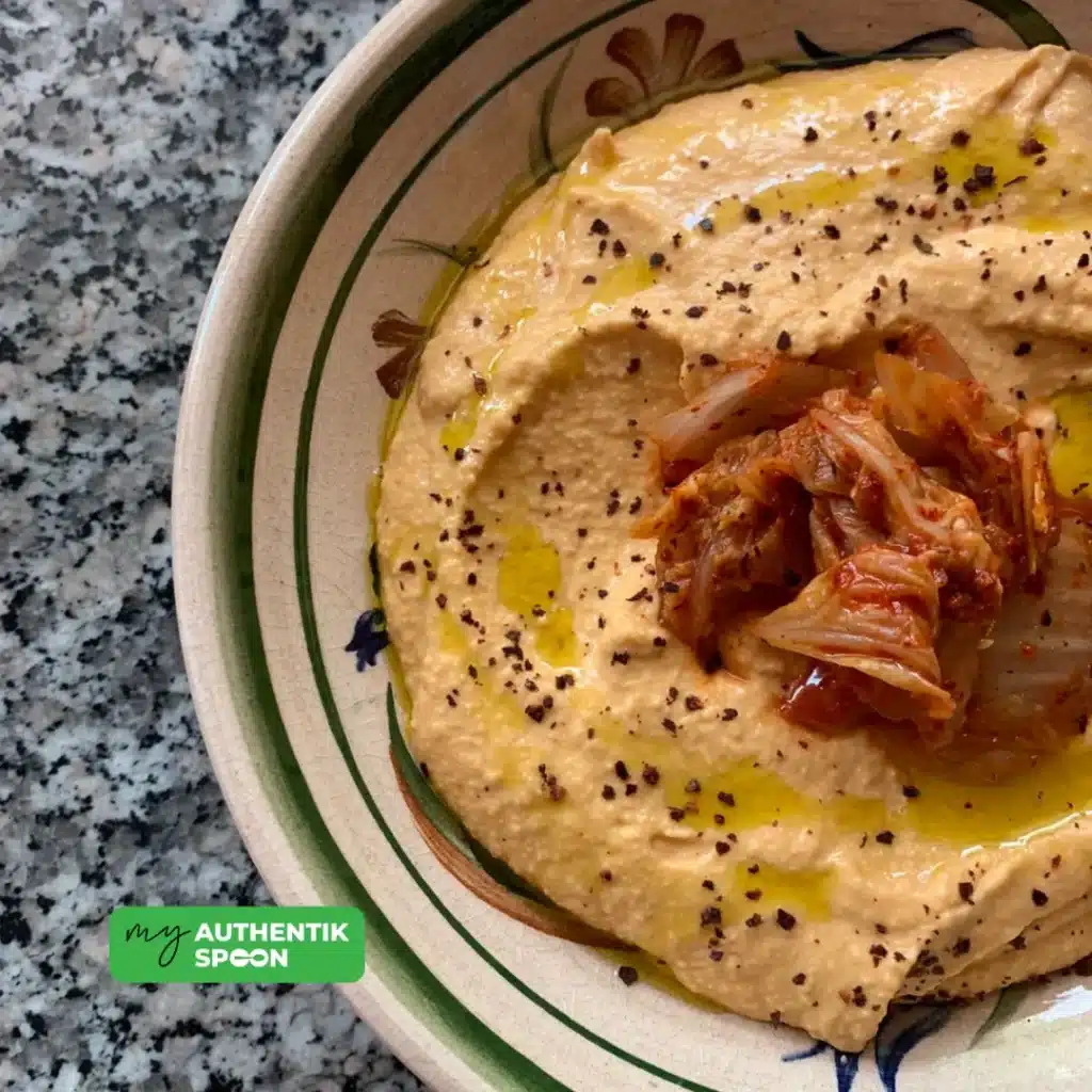 Kimchi hummus recipe topped with olive oil and kimchi for gut health