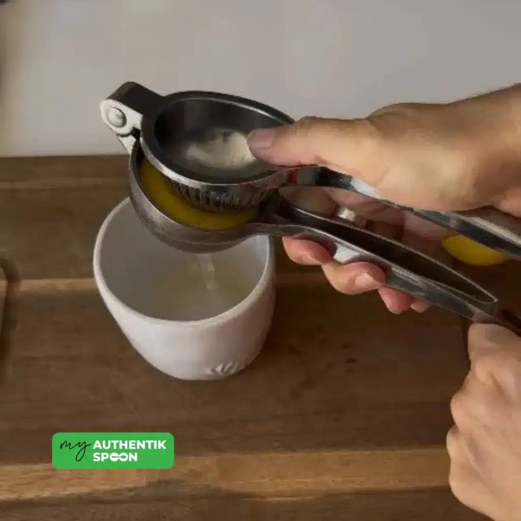 Squeezing fresh lemon into a cup to prepare the morning drink for better digestion.