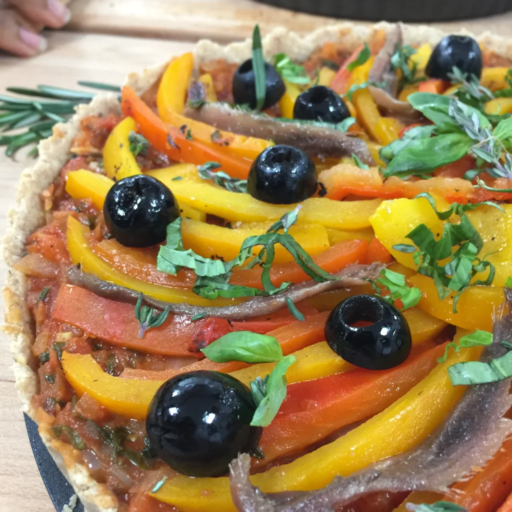 Close-up of olives and anchovies on a gluten free pissaladière
