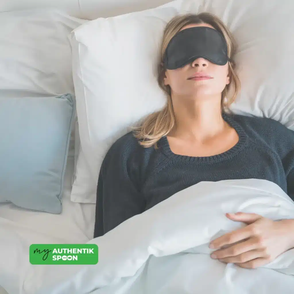 Woman resting in bed with sleep mask, illustrating one of the key habits for weight loss and hormonal balance