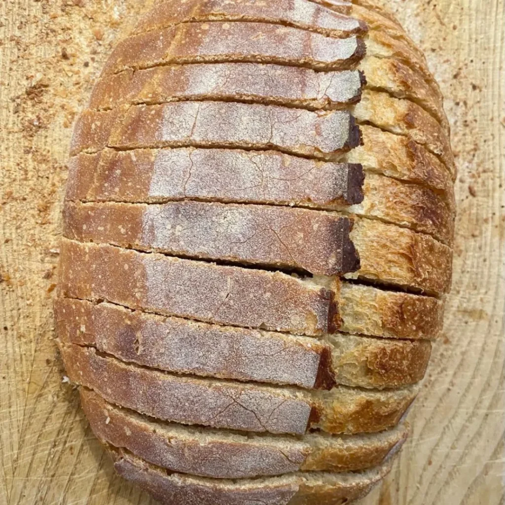 Sliced traditional sourdough bread showing an artisan crust and naturally fermented crumb