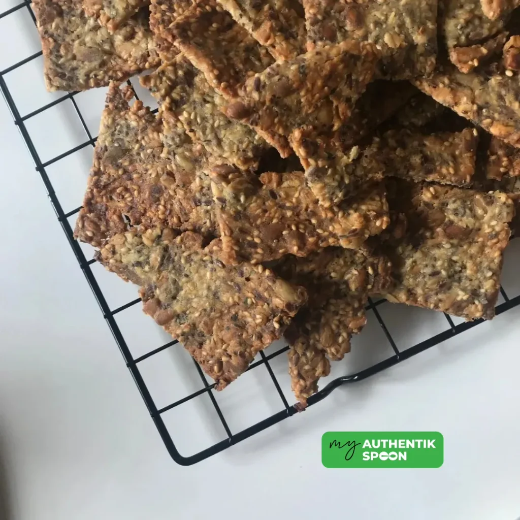 homemade gluten free seed crackers cooling on a black wire rack