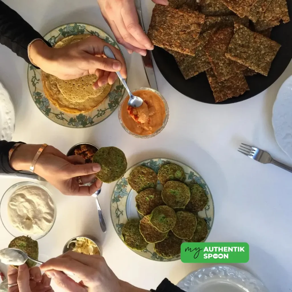 healthy gluten free snacks on a sharing table with seed crackers, pancakes and dips