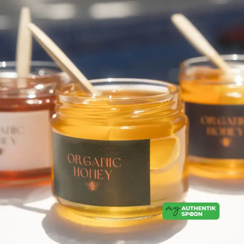 Jar of organic honey with a wooden stick, a natural healthy sweetener rich in antioxidants.