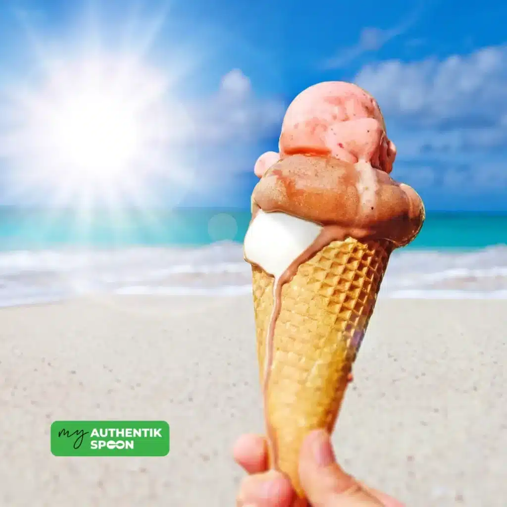 Hand holding a melting ice cream cone on the beach in summer sunlight