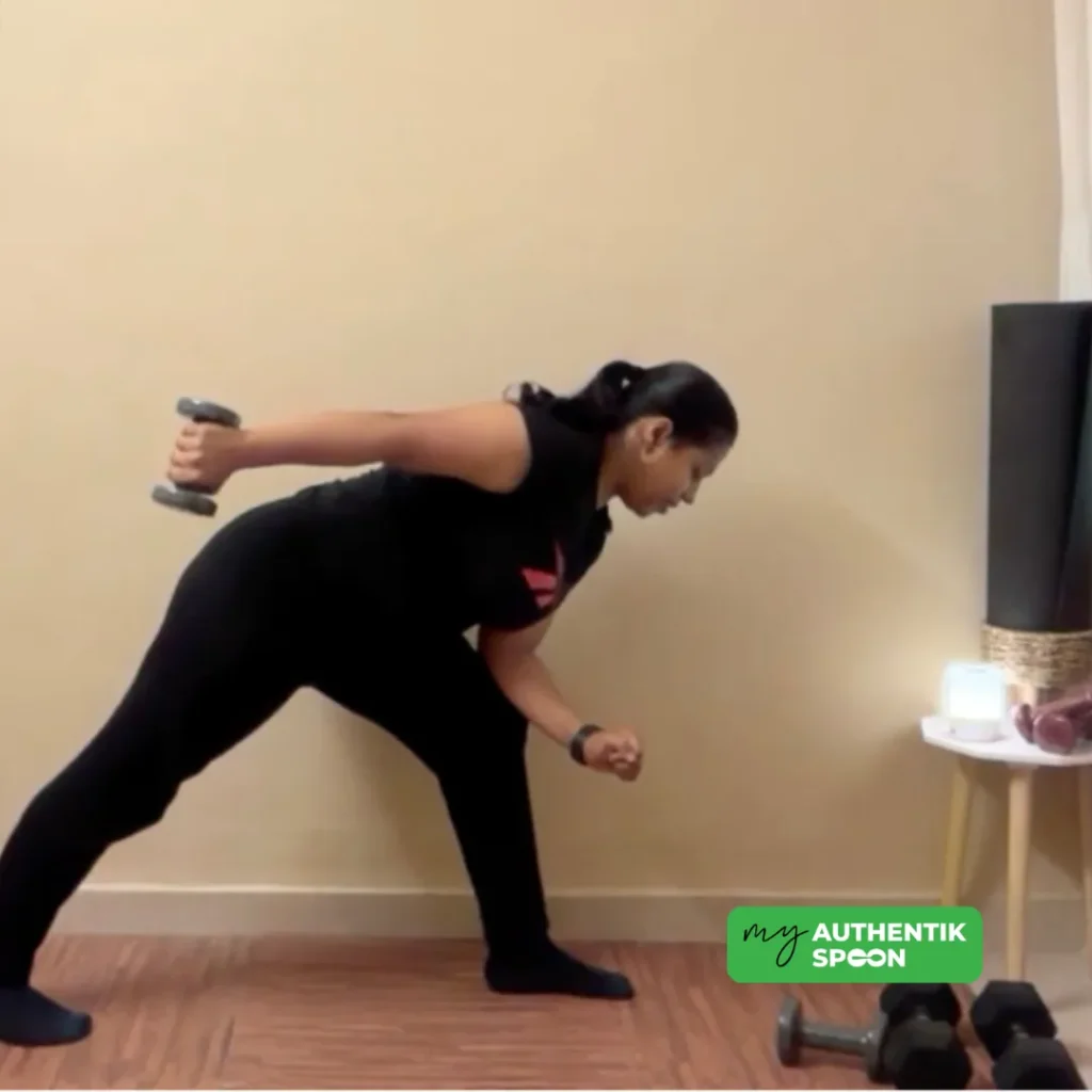 Woman performing a dumbbell tricep kickback exercise to combat muscle loss after 35