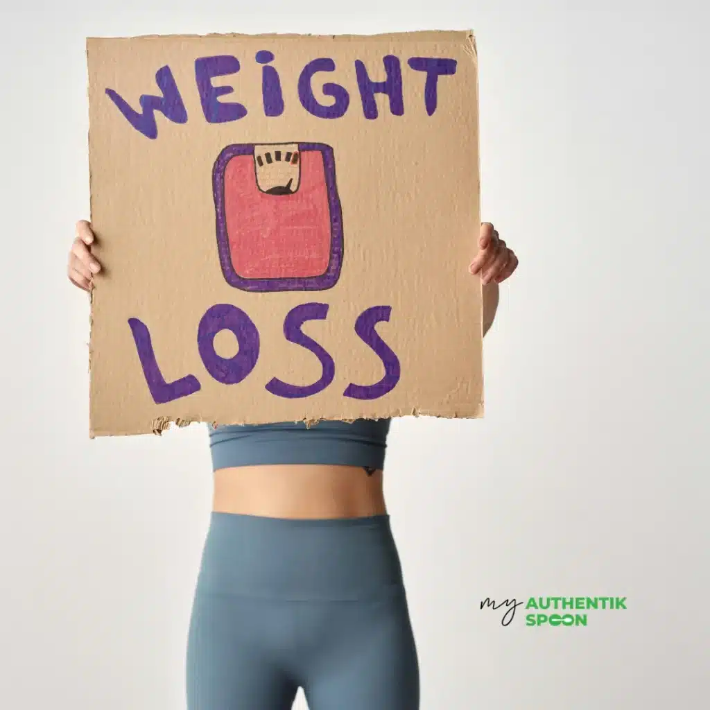 Woman holding “weight loss” sign illustrating sustainable weight loss and realistic healthy lifestyle habits